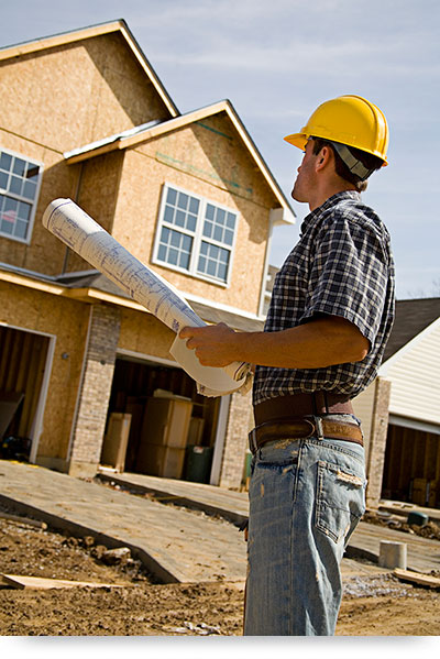 Commercial General Contractor 1 Contractor standing by house with floorplans1